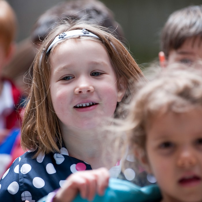 Smiling Casa age child in a polka dot raincoat.