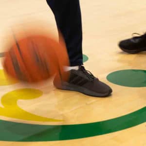 An action shot of a child playing basketball.