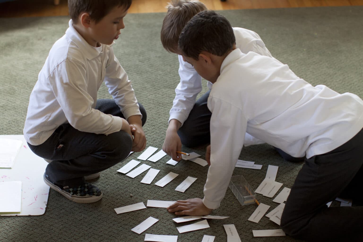 Three Elementary boys work together with grammar materials.